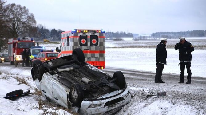 Ein Fahrzeug liegt bei Ringschnait nach einem Unfall auf einer winterlichen Straße auf dem Dach.