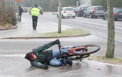 Ein Fahrradfahrer liegt bei extremer Glätte auf einem Radweg, nachdem er zuvor ausgerutscht war. Spiegelglatte Wege im Norden ha