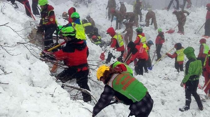 Rettungskräfte arbeiten sich in der Nähe des von einer Lawine vershütteten Hotels durch die Schneemassen. Foto: The National