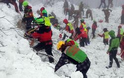 Rettungskräfte arbeiten sich in der Nähe des von einer Lawine vershütteten Hotels durch die Schneemassen. Foto: The National 