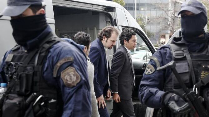 Zwei der insgesamt acht türkischen Soldaten werden in Athen von Polizisten in ein Verwaltungsgericht geführt. Foto: Yorgos Ka Zwei der insgesamt acht türkischen Soldaten werden in Athen von Polizisten in ein Verwaltungsgericht geführt. Foto: Yorgos Ka