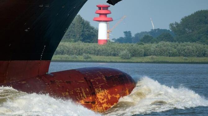 Der Bug eines Containerfrachters schiebt vor der Hamburger Hafeneinfahrt eine große Welle vor sich her. Foto: Axel Heimken