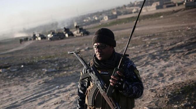 Ein irakischer Polizist hält bei Hammam Al-Alil ein Sprechfunkgerät in der Hand. Die Schlacht um Mossul geht mit dem Sturm au