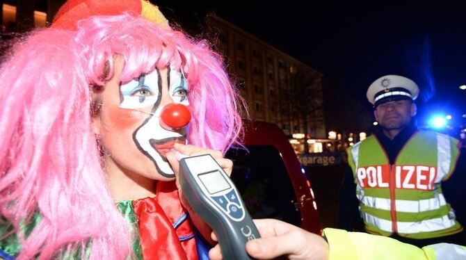 Ein als Clown verkleideter Fastnachtsnarr muss in Freiburg bei einer Alkoholkontrolle der Polizei in ein Messgerät pusten. Ein als Clown verkleideter Fastnachtsnarr muss in Freiburg bei einer Alkoholkontrolle der Polizei in ein Messgerät pusten.