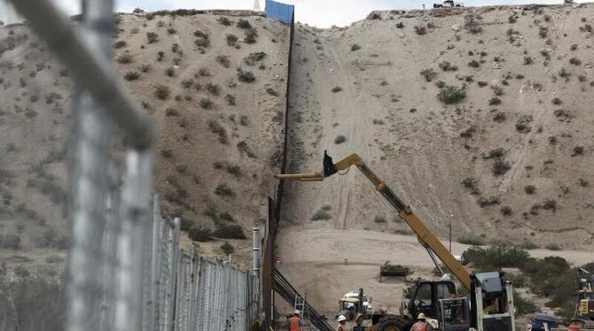 Arbeiter bauen im vergangenen Novmeber an der Erhöhung des Grenzzaunes zwischen USA und Mexiko. Foto: Christian Torres