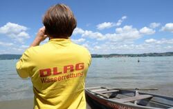 Ein Rettungsschwimmer der Deutschen Lebensrettungsgesellschaft (DLRG) beobachtet Schwimmer an einem Strandbad am Bodensee. Fo