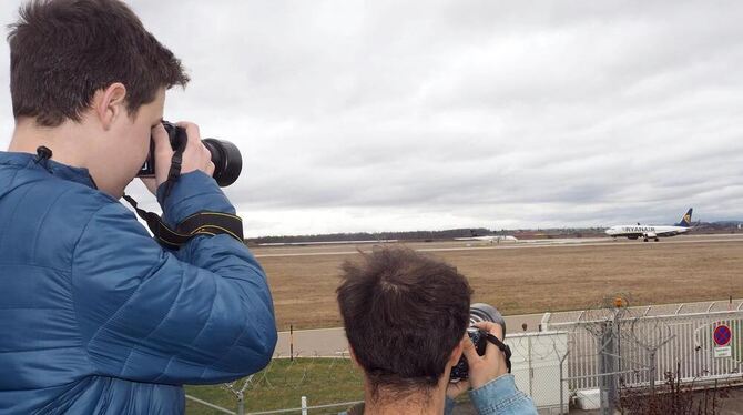 Nils (links) und Marco fotografieren am Flughafen Stuttgart ein startendes Verkehrsflugzeug.