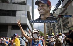 Eine Frau trägt ein T-Shirt und ein Plakat mit dem Konterfei des venezolanischen Oppositionsführers Henrique Capriles. Foto: 