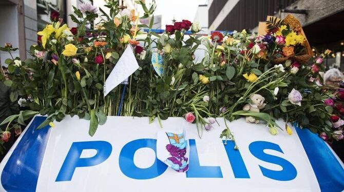 Blumen liegen auf einem Polizeifahrzeug in der Innenstadt von Stockholm. Foto: Linnea Rheborg/Bildbyran