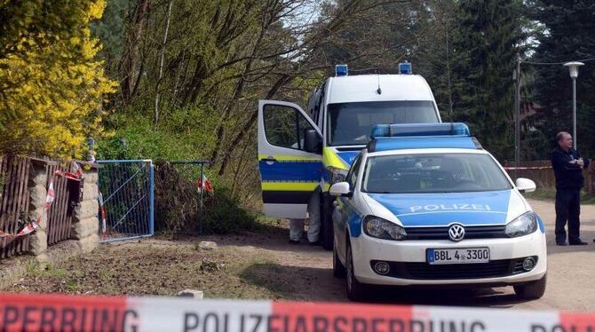 Polizisten sperren in Borkheide die Straße ab. Ein Jugendlicher soll seine Mutter getötet haben. Foto: Julian Stähle