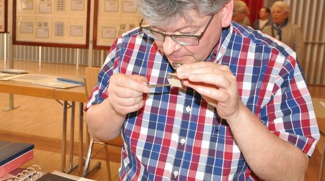 Jürgen Stoll nimmt die Briefmarken ganz genau unter die Lupe. FOTO: BIMEK Jürgen Stoll nimmt die Briefmarken ganz genau unter die Lupe. FOTO: BIMEK
