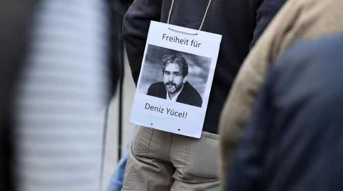 Ein Mann hat sich am 13. April während einer Mahnwache in Hessen ein Transparent mit der Aufschrift "Freiheit für Deniz Yücel
