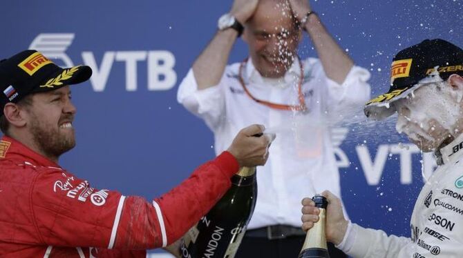 Sebastian Vettel duscht den Sotschi-Sieger Valtteri Bottas mit Champagner ab. Foto: Pavel Golovkin