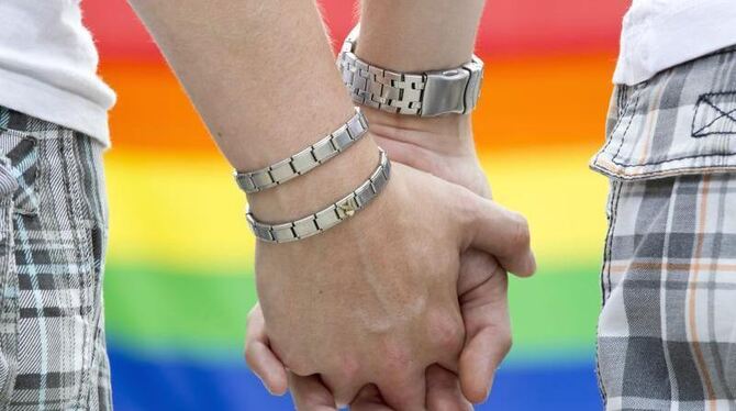 Zwei Männer halten sich an der Hand.