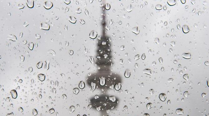 Es will nicht wirklich schön und warm werden: Der Hamburger Fernsehturm spiegelt sich in den Regentropfen auf einer Autoschei