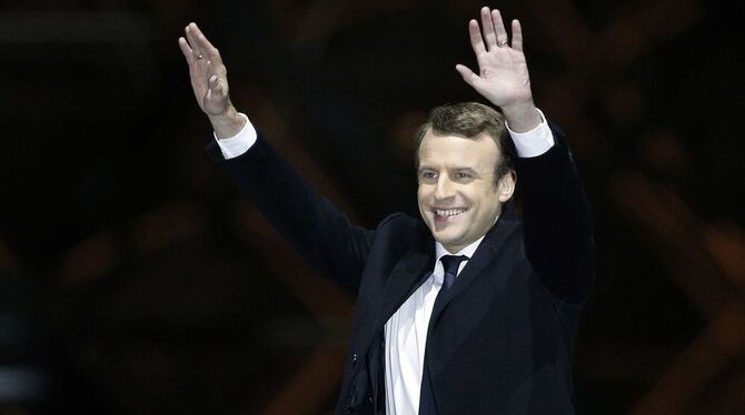 Der sozialliberale Kandidat Emmanuel Macron winkt in Paris nach dem Sieg bei der Präsidentenwahl seinen Anhängern am Louvre zu.