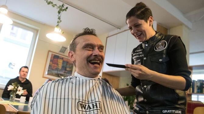 Ein Besucher der Tagesstätte für Wohnungslose der Caritas bekommt in Stuttgart während einer Haarschneideaktion der "Barber Ange