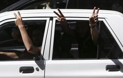 Anhänger des iranischen Präsidenten Ruhani zeigen Siegeszeichen aus ihrem Auto in Teheran. Foto: Vahid Salemi