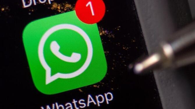 Das Logo der Messenger-App WhatsApp ist auf dem Display eines Smartphones zu sehen.