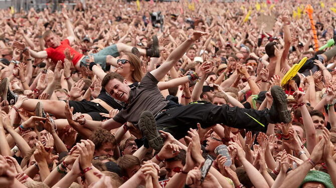 Crowdsurfer lassen sich in Nürburg vor der Hauptbühne des Musikfestivals Rock am Ring während des Auftritts der Band »Broilers«