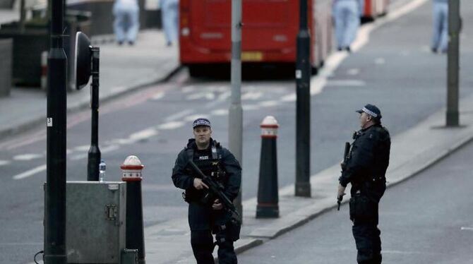 Bewaffnete Polizisten sichern Mitarbeiter der Spurensicherung im Hintergrund, die auf der London Bridge in London nach dem Te
