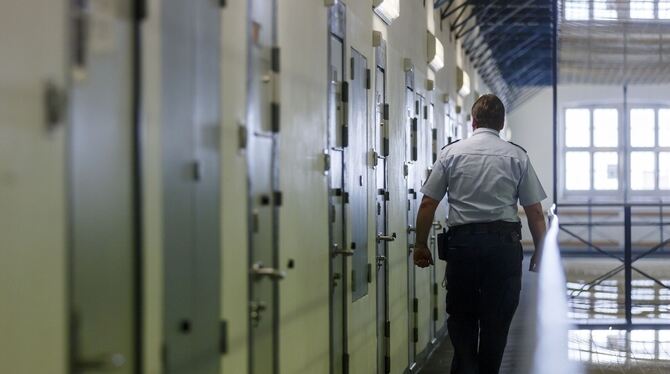 Ein Vollzugsbeamter geht beim Kontrollgang in der Justizvollzugsanstalt in Bruchsal an den Zellentüren der Insassen vorbei.