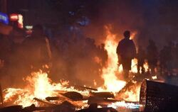 Aktivisten stehen im Hamburger Schanzenviertel vor einer brennenden Barrikade. Foto: Boris Roessler