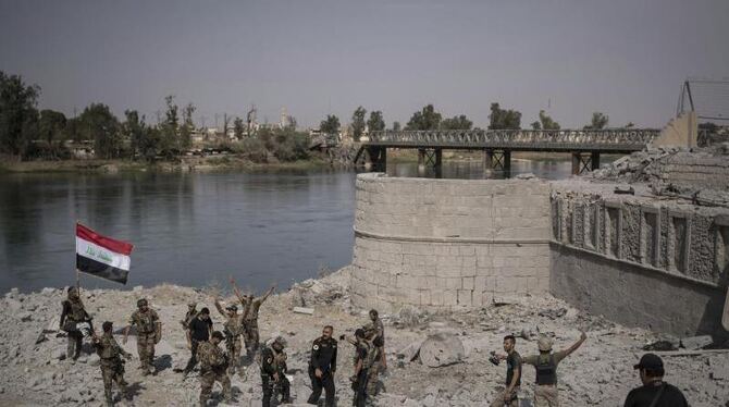 Spezialeinheiten hissen die irakische Fahne am Ufer des Tigris in Mossul. Foto: Felipe Dana
