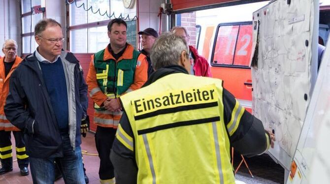 Stephan Weil (l), Ministerpräsident von Niedersachsen, informiert sich bei der Feuerwehr in Eldagsen über die Hochwasserlage.