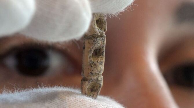 Archäologin Sybille Wolf betrachtet in Blaubeuren eine rund 40.000 Jahre alte Perle aus Mammutelfenbein.