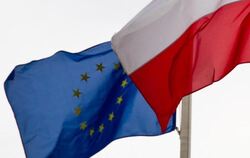 Eine EU-Flagge weht neben einer polnischen Flagge. Die EU-Kommission hat ein Vertragsverletzungsverfahren gegen Polen eingele