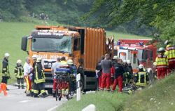 Feuerwehrkräfte arbeiten auf einer Straße bei Nagold an einer Unfallstelle, an der ein Müllwagen auf ein Auto gekippt war. Fo