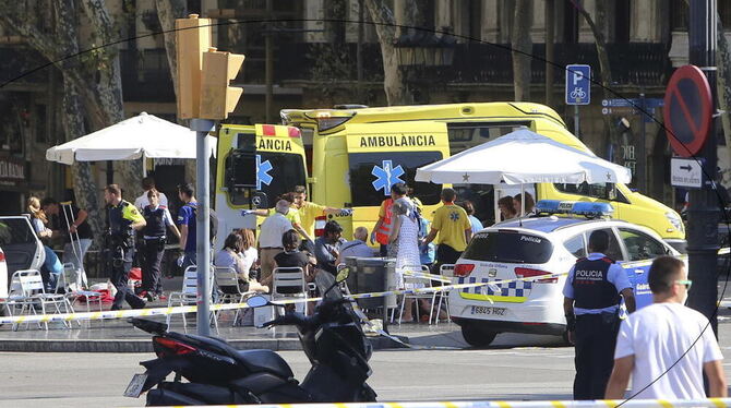 Sanitäter versorgen in Barcelona verletzte Menschen. Auf der Flaniermeile Las Ramblas ist ein Lieferwagen in eine Menschenmenge
