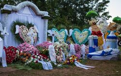 Ein Meer aus Kränzen, Blumen und Gestecken sowie bunte Mickey-Maus-Figuren mit Luftballons sind nach der Trauerfeier und Beerdig