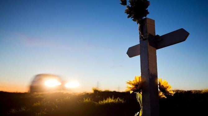 Ein Kreuz und Blumen zur Erinnerung an einen Verkehrstoten an einer Landstraße in Niedersachsen. Foto: Julian Stratenschulte