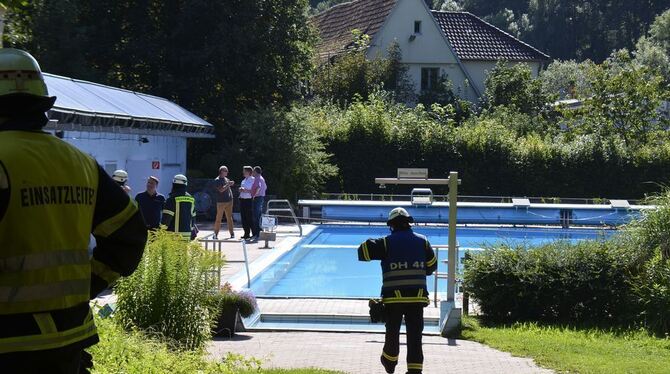 Feuerwehrmänner stehen im Freibad in Dettenhausen nach einem Austritt von Chlorgas auf dem Gelände. Es gab fünf Verletzte. Foto: