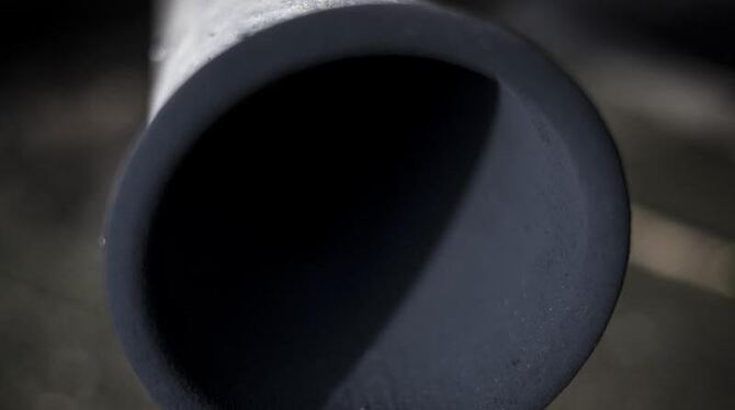 Eine Schicht mit schwarzem Ruß bedeckt das Innere des Auspuffs eines Kleintransporters. Foto: Christian Charisius/Illustratio