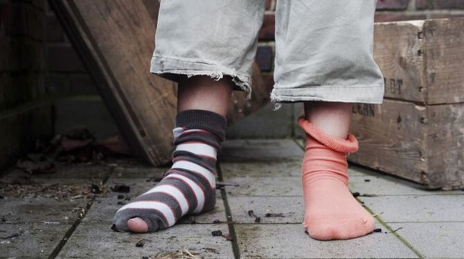 Ein zehn Jahre altes Mädchen steht in abgetragener Kleidung ohne Schuhe in einem Hinterhof in Hamburg. Foto: Christian Hager