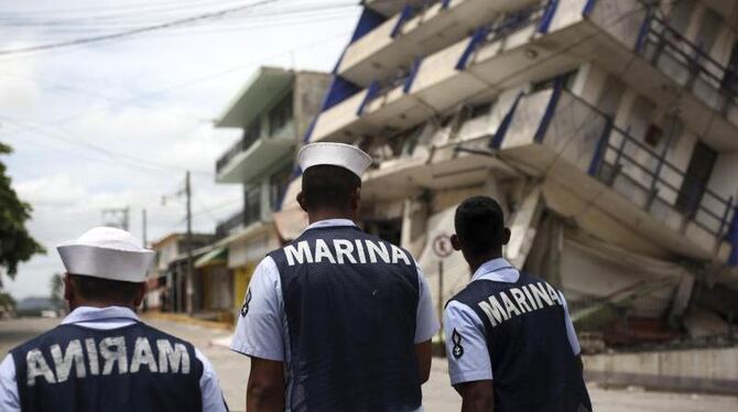 Mitglieder der mexikanischen Marine gehen in Matias Romero an einem teilweise zusammengestürzten Hotel vorbei. Foto: Felix Ma