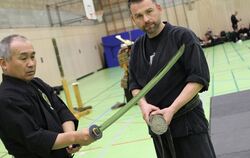 Die brillante Schärfe einer japanischen Katana führte der Meister (links) vor. Eine nasse, eng zusammengerollte Strohmatte, dien