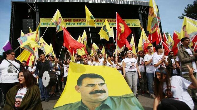 Kurden schwenken im September 2016 in Köln Fahnen mit dem Bild von PKK-Gründer Öcalan. Foto: Oliver Berg