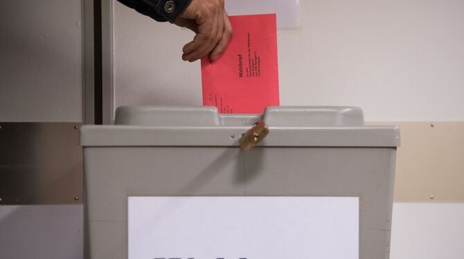 Ein Wähler steckt in Stuttgart einen Wahlbrief zur Bundestagswahl in eine Wahlurne.