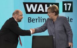 Bundeskanzlerin Angela Merkel (CDU) gibt dem SPD-Vorsitzenden Martin Schulz in Berlin vor einer Fernsehrunde der Parteivorsitzen