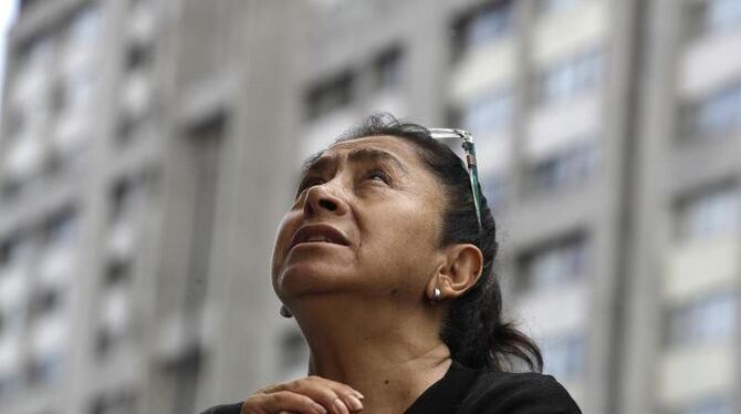 Eine Frau betet bei einer Messe für die Opfer des Erdbebens unter freiem Himmel in Mexiko-Stadt. Foto: Rebecca Blackwell
