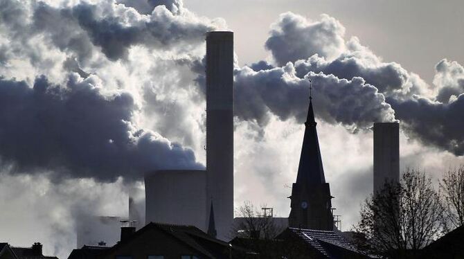 Rauch und Dampf steigen aus den Kühltürmen und Schornsteinen eines Braunkohlekraftwerks. Foto: Oliver Berg