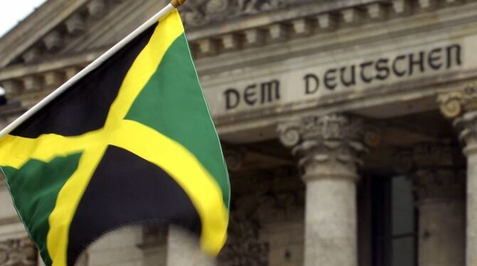 ARCHIV - ILLUSTRATION - Eine in den Boden gesteckte jamaikanischen Flagge weht vor dem Reichstag in Berlin.