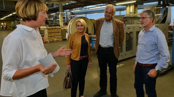 Geschäftsführerin Ulrike Köhler (links) zeigt dem amerikanischen Verleger Peter Barbey (rechts) und seiner Frau Pamela das Druck