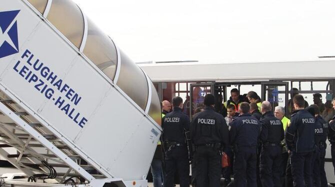 Polizisten überwachen eine Sammelabschiebung auf dem Flughafen Leipzig-Halle. Foto: Sebastian Willnow
