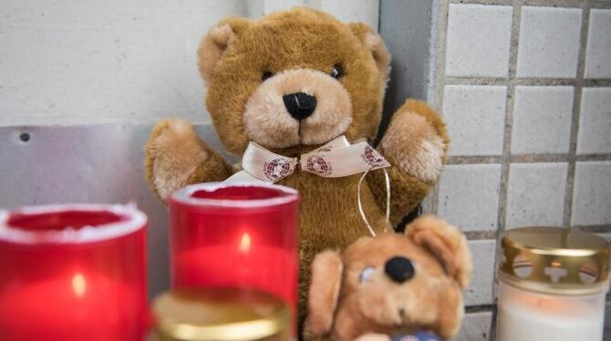 Kerzen und Teddybären aus Stoff stehen Hamburg-Neuwiedenthal vor einem Mehrfamilienhaus. Ein zweijähriges Mädchen ist in Hamb