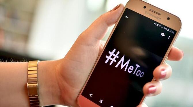 Eine junge Frau hält ein Smartphone mit dem Hashtag »#MeToo«. Foto: Britta Pedersen